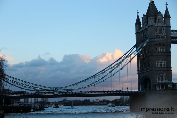 Tower Bridge vakaro saulės debesų apšiestame fone.